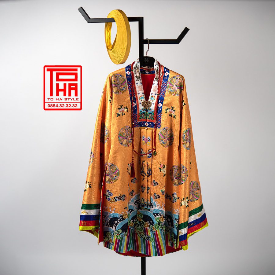 Bộ trang phục truyền thống Việt Nam: áo Nhật Bình cho nữ màu vàng đậm, chất liệu gấm thêu hoa văn phượng ổ Bộ trang phục truyền thống Việt Nam: áo Nhật Bình cho nữ màu vàng đậm, chất liệu gấm thêu hoa văn phượng ổ